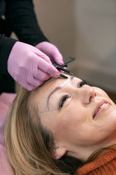 Aesthetician Measures Eyebrows Of Client