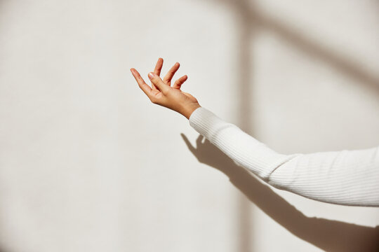 Minimalist close-up of an arm and hand in sunlight