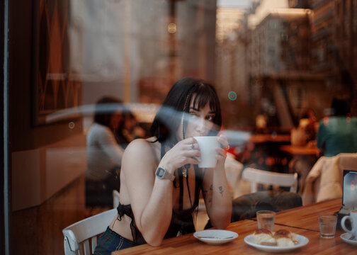 Woman enjoying coffee at cafe - Powered by Adobe