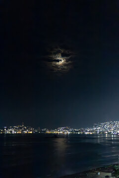 Acapulco bay illuminated by moonlight and artificial light at night