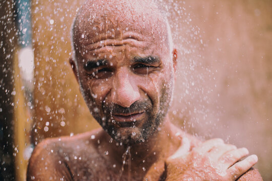 Man enjoying a refreshing water shower outdoors during warm weather