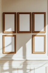 Five empty gold frames on a beige wall.