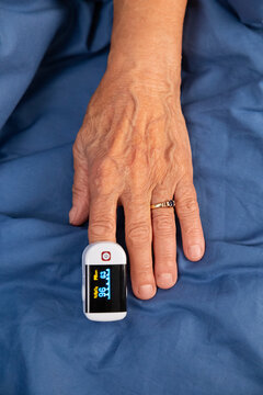 Senior patient using pulse oximeter on finger 