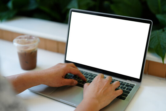 Close up woman hand using and typing on laptop blank white screen.