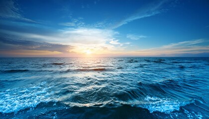 Obraz premium A breathtaking sunset casts a golden glow over the vast deep blue ocean