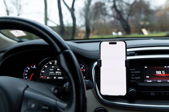 Blank Screen mobile phone in car holder with view 