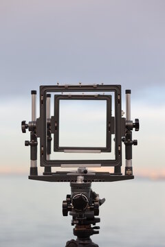 Camera lens with a black frame is set up on a tripod