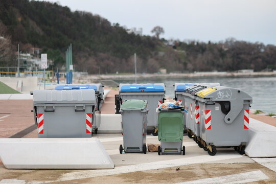 Row of trash cans are lined up on a beach