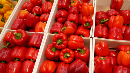 Lots of red bell peppers in market boxes
