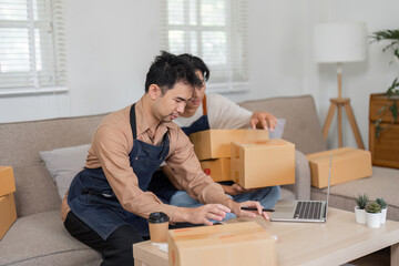 Dynamic social media marketers organizing product packages while collaborating in their home office