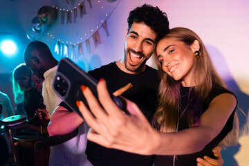Young couple takes selfie at lively birthday celebration