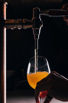 Pouring a glass of beer from a tap with warm lighting