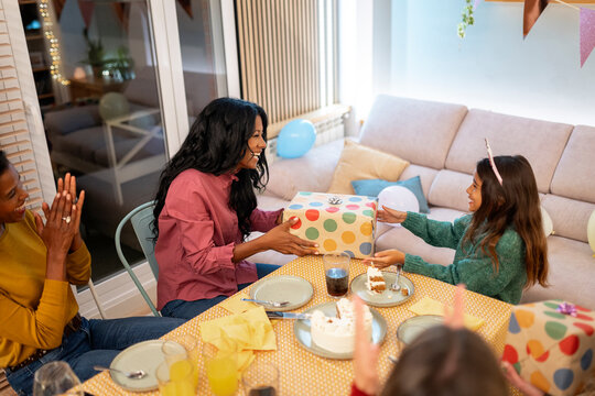 mother gives a gift to her daughter during birthday celebrations