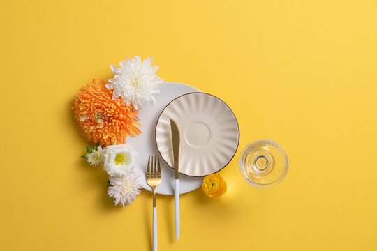 Elegant Table Setting with Flowers and Yellow Background