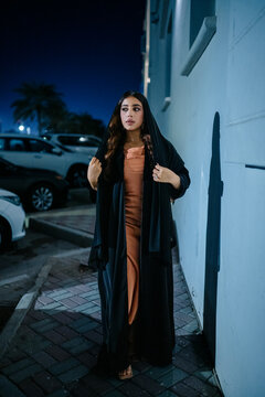 Elegant muslim woman wearing traditional abaya and shayla at night