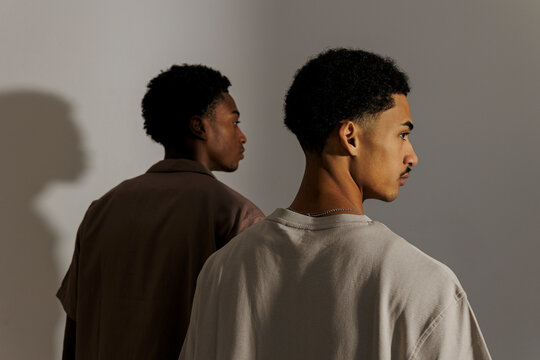 Two fashion models looking away in neutral background