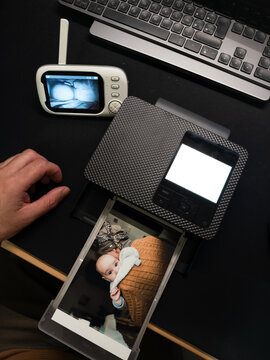 Father printing photo of baby with portable printer