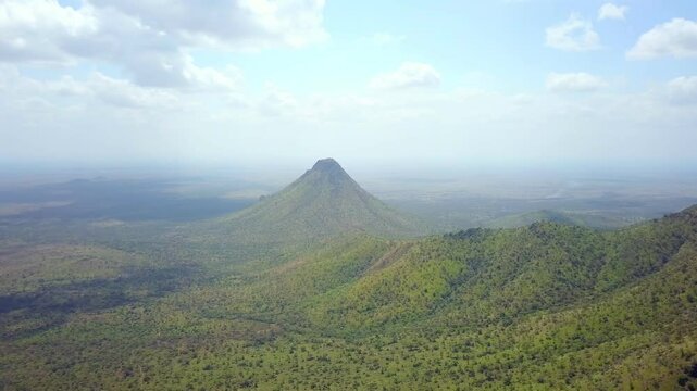 Drone shot of Mount Kadam, the highest mountain in Karamoja, Uganda, rising above the surrounding landscape, showcasing the natural beauty and tranquility of the region