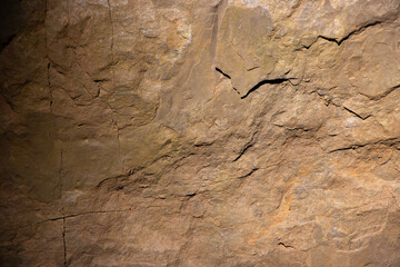 Brown stone background, rock wall backdrop with rough texture. Abstract, grungy and textured surface of stone material. Nature detail of rocks