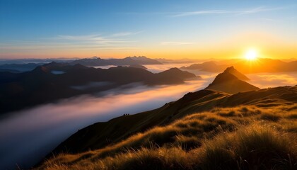 Naklejka premium Sunrise over misty mountain range with golden grassy slopes, blue sky, and distant peaks fading into the horizon.