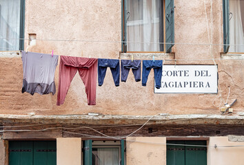 House facade in Venice with drying laundry and street name