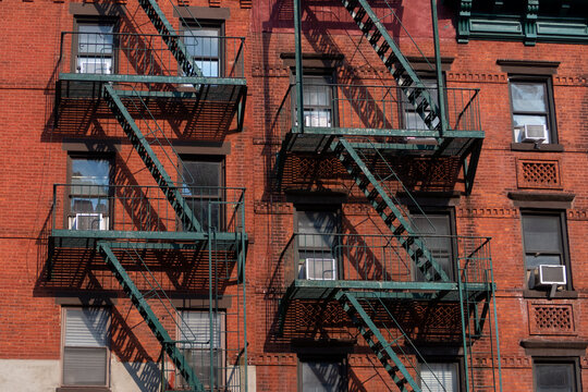 Red bulding facade with green fire escape stairs at Manhattan
