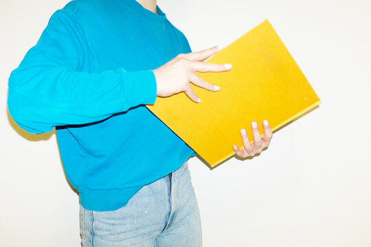 Person reading a yellow book in office workplace with hard flash