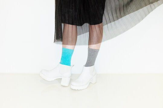 Person with fashion style skirt and different pair of socks and heels