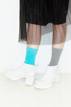 Person with fashion style skirt and different pair of socks and heels