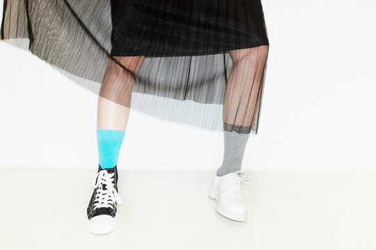 Person with fashion style skirt and different pair of socks and shoes