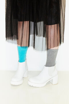Person with fashion style skirt and different pair of socks and heels