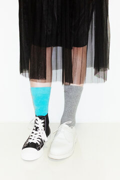 Person with fashion style skirt and different pair of socks and shoes
