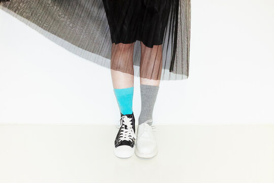 Person with fashion style skirt and different pair of socks and shoes