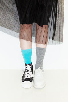 Person with fashion style skirt and different pair of socks and shoes