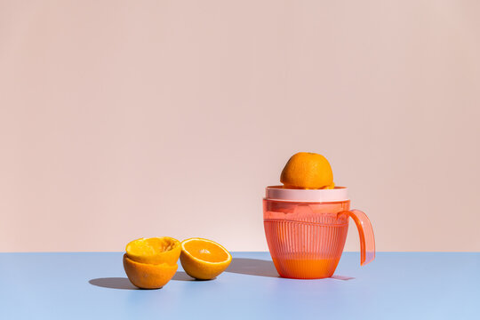 Citrus juicer / squeezer with half-squeezed orange. Making juice. 