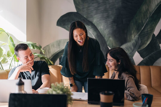 Coworkers laughing together during a business meeting