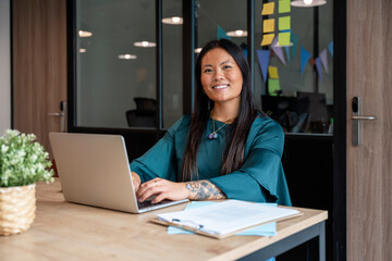 Smiling professional working on laptop in office