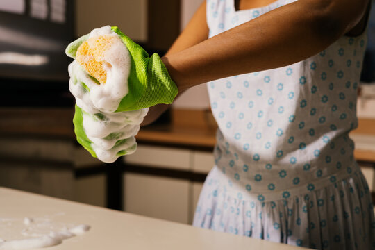 Anonymous woman wrings out soapy sponge