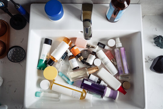 Aerial shot of sink filled with tubes, cans and bottles of creams
