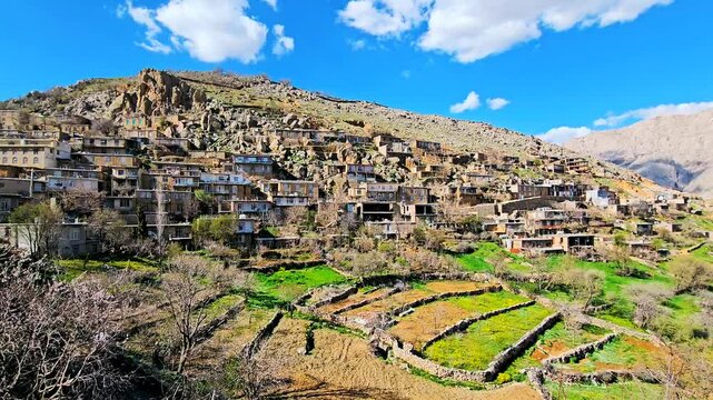 Picturesque mountain village with terraced fields under a bright blue sky.
📍Sarpir village, Hawraman Takht 