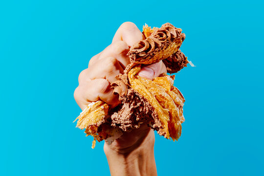 man squeezes with his hand a piece of cake