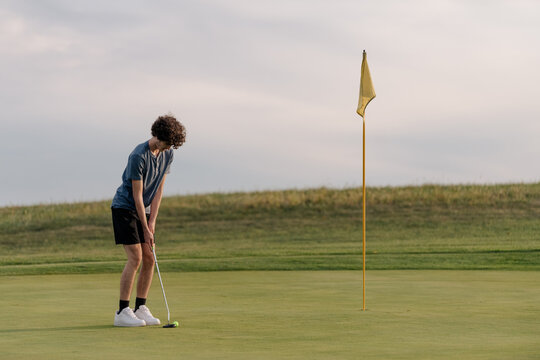 Teenage boy golfing