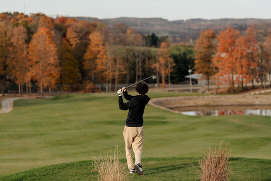 Teenage boy golfing