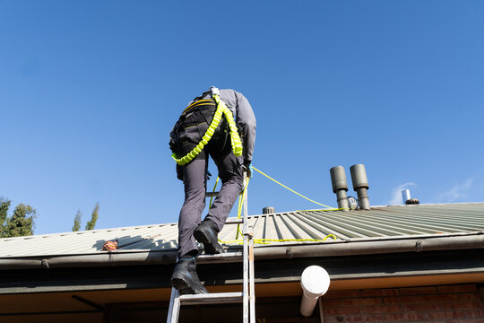 Worker Securing Roof Safety Line