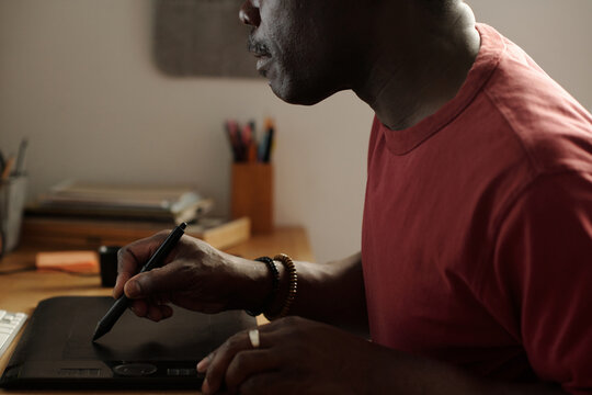 Adult Black Man Using Graphic Tablet when Working at Home