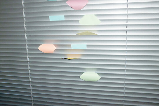 colourful post it notes on window bind wityh hard direct flash