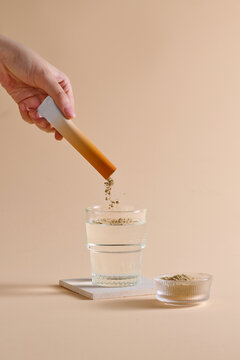 An aesthetic image showing powder being dissolved into a glass