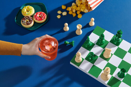 Chess Game with Snacks and Drinks on a Blue Table