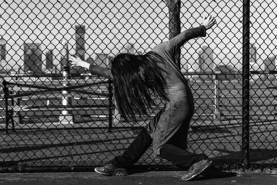Woman leaning against chain-link fence