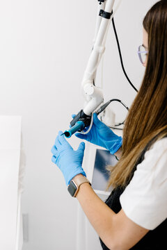 Skilled dermatologist manipulating specialized medical equipment
